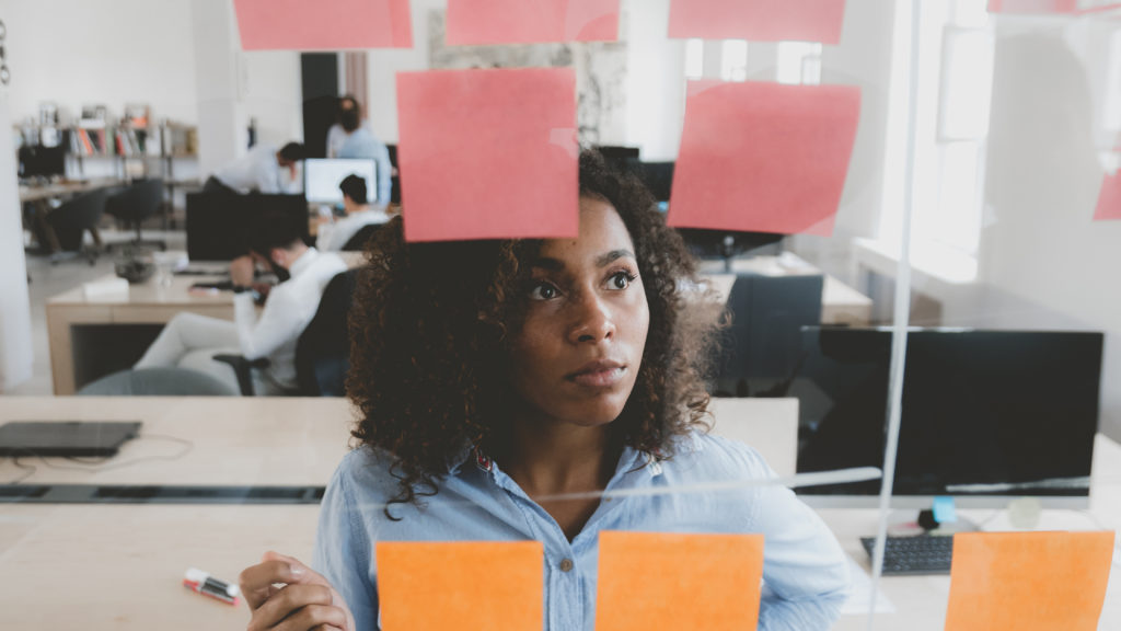 Woman in front of sticky notes on a clear board