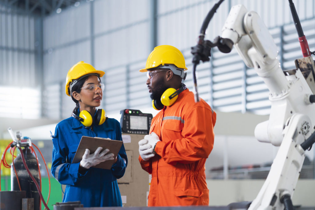 Two people in coveralls and hardhats