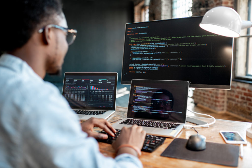 Man at desk in front of multiple computers