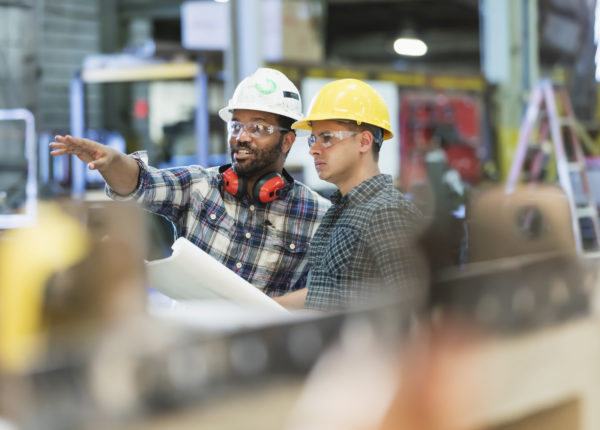 Two men with hardhats and safety goggles