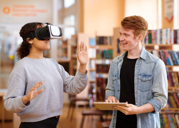 Woman with VR headset on beside another person