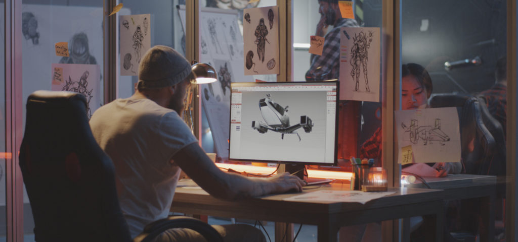 Man looking at monitor with model of airplane