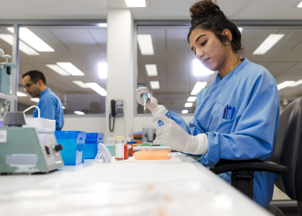 Woman in a lab using a pipette