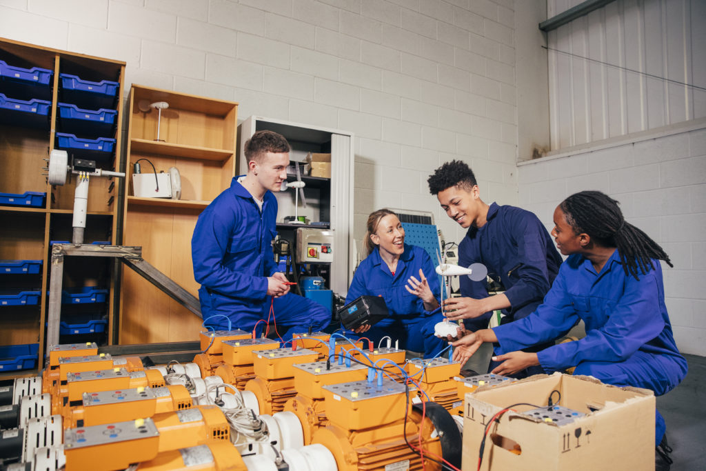 Group of people in overalls handling electronics