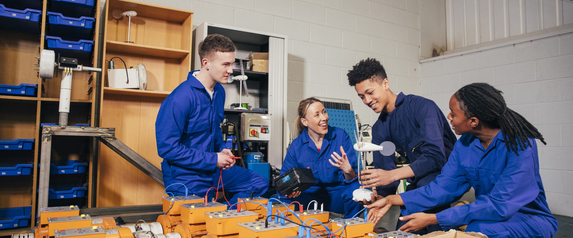 Group of people in overalls handling electronics