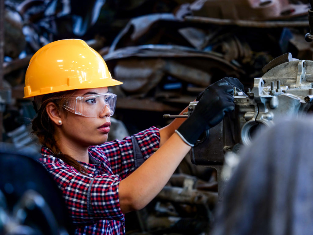 Young Asian Engineer woman working with machine in factory.